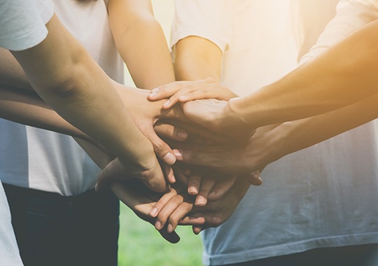 Group of people in a circle with their hands together