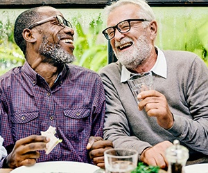 Older patient with dental implants in Hammonton smiling with a friend