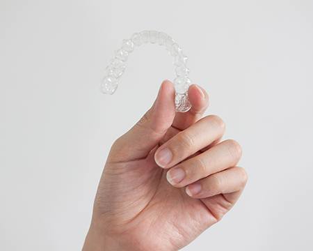 Woman holding clear aligner