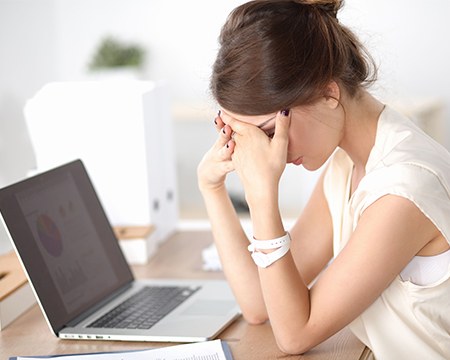 Frustrated tired woman with head in hands