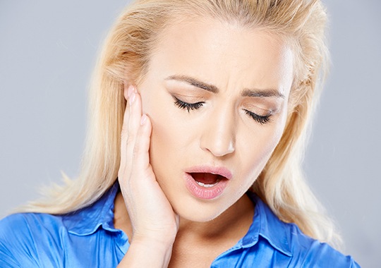 Woman in pain holding jaw