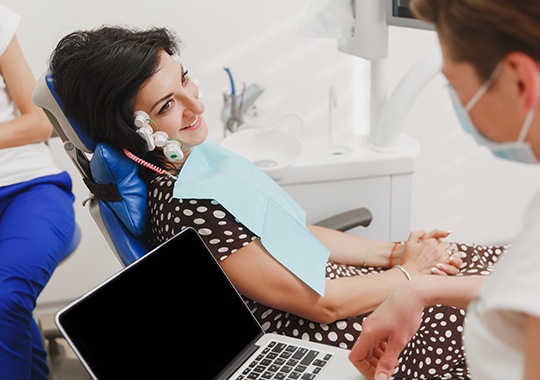 Woman in dental chair receiving TMJ treatment