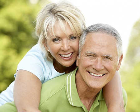 Woman and man smiling outdoors