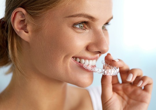 Woman placing Invisalign tray