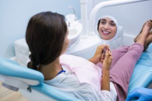 person smiling while sitting in dentist's chair