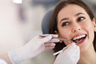 Woman with brown hair getting a gum exam from a dentist