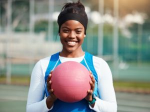 a woman holding a basketball and smiling